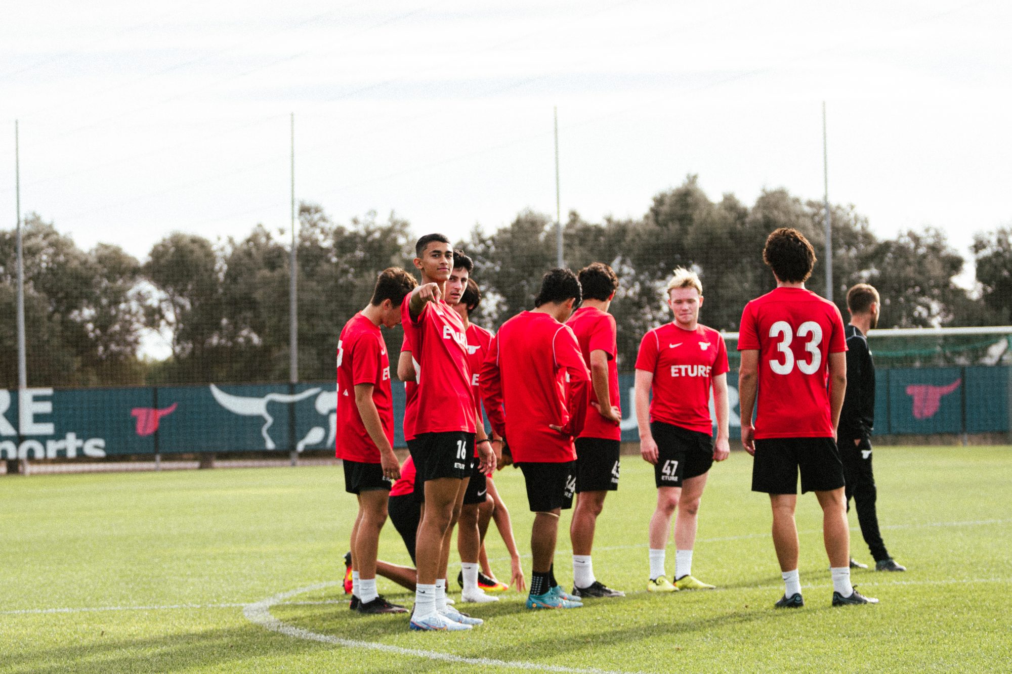 ETURE FC players in a team huddle on the pitch